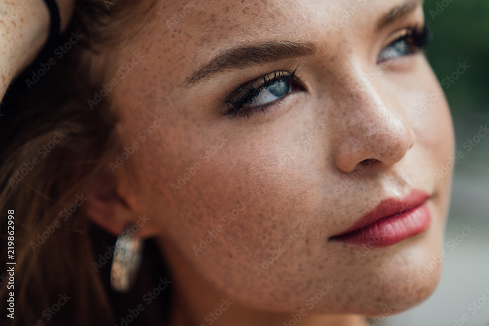Extreme close-up of freckled woman with blue eyes