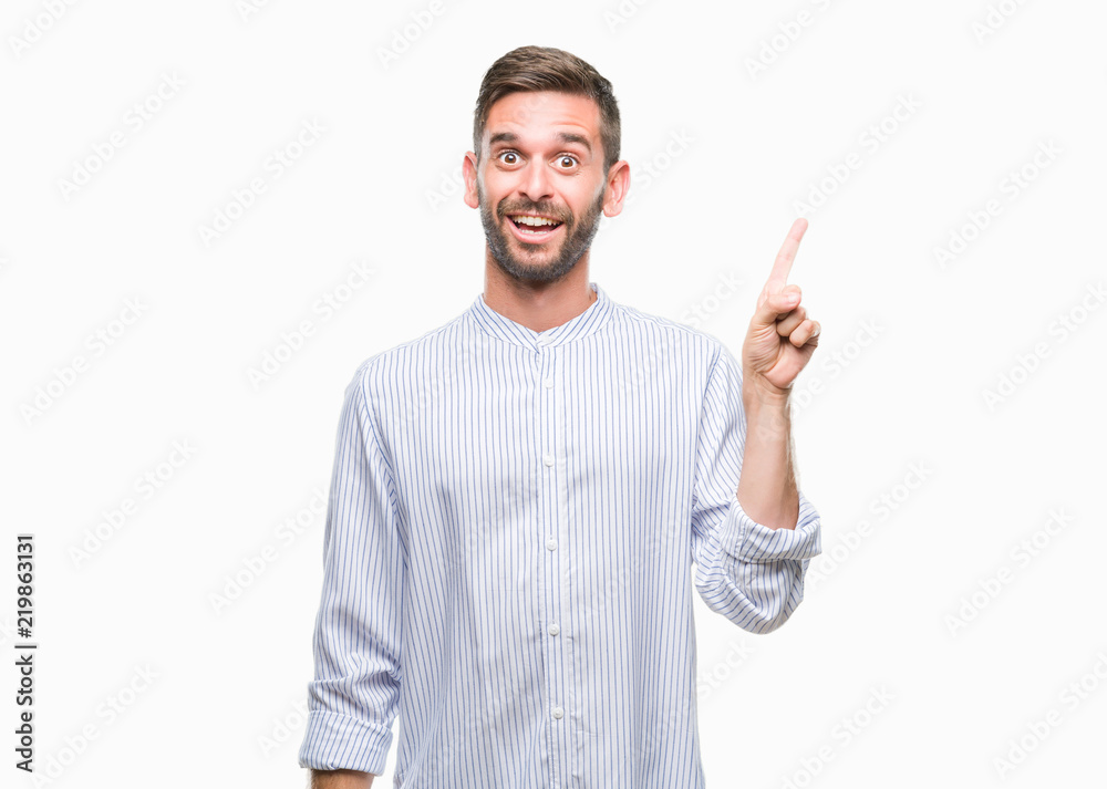 Young handsome man over isolated background with a big smile on face, pointing with hand and finger to the side looking at the camera. Young handsome man over isolated background with a big smile on face, pointing with hand and finger to the side looking at the camera.