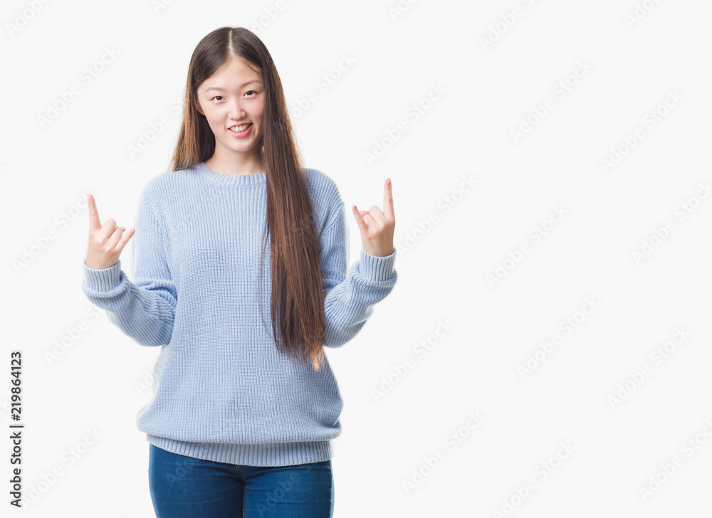 Young Chinese woman over isolated background shouting with crazy expression doing rock symbol with hands up. Music star. Heavy concept. Young Chinese woman over isolated background shouting with crazy expression doing rock symbol with hands up. Music star. Heavy concept.