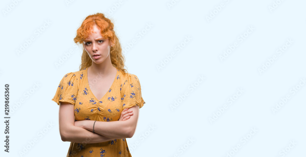 Young redhead woman skeptic and nervous, disapproving expression on face with crossed arms. Negative person. Young redhead woman skeptic and nervous, disapproving expression on face with crossed arms. Negative person.