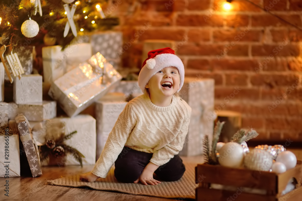 Cute little boy wearing Santa hat on Christmas eve Cute little boy wearing Santa hat on Christmas eve