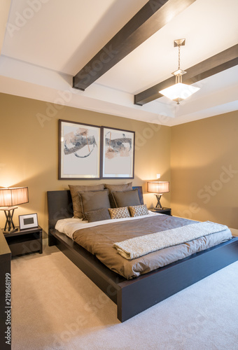 Modern bright bedroom interior with designer pillows in a luxury house.
