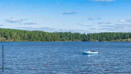 fisherman in a boat catching fish on the lake on summer day