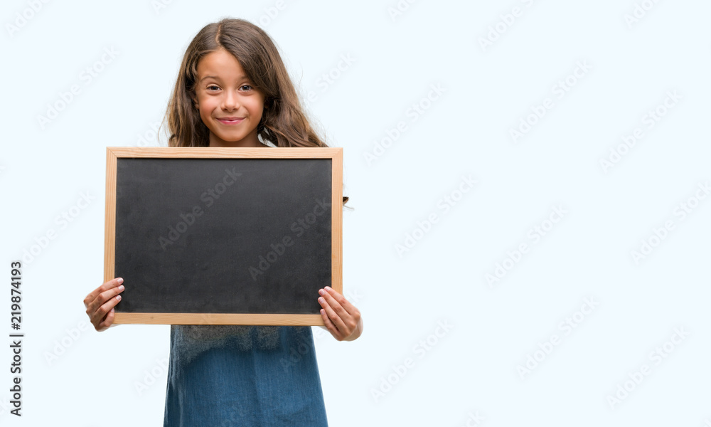 Brunette hispanic girl holding blackboard with a happy face standing and smiling with a confident smile showing teeth Brunette hispanic girl holding blackboard with a happy face standing and smiling with a confident smile showing teeth