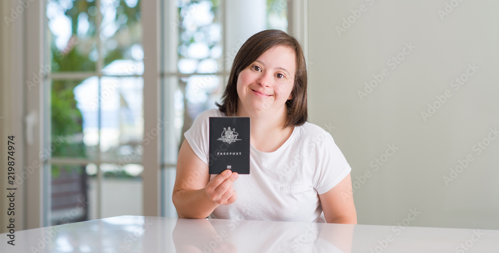Down syndrome woman at home holding australian passport with a happy face standing and smiling with a confident smile showing teeth Down syndrome woman at home holding australian passport with a happy face standing and smiling with a confident smile showing teeth