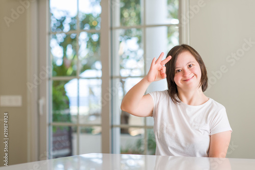 Down syndrome woman at home smiling positive doing ok sign with hand and fingers. Successful expression. Free Download Down syndrome woman at home smiling positive doing ok sign with hand and fingers. Successful expression. - GFXLoad