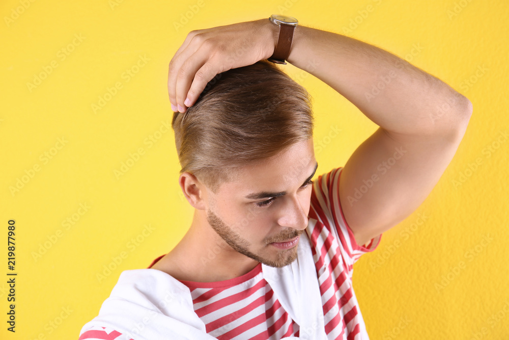 Young man with trendy hairstyle on color background Young man with trendy hairstyle on color background