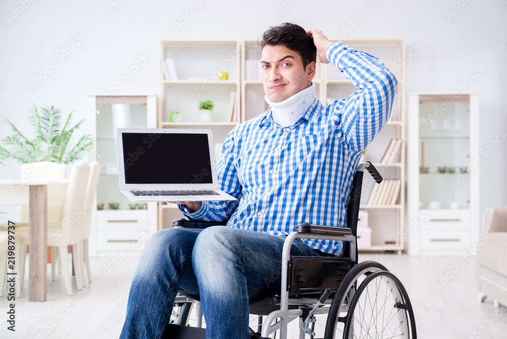 Young man suffering from injury on wheelchair at home Young man suffering from injury on wheelchair at home