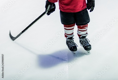 Closeup of Child Legs Playing Ice Hockey in Arena