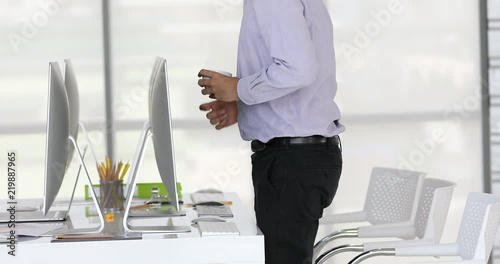 Businessman raise from chair after work, collect things and walk away form working desk