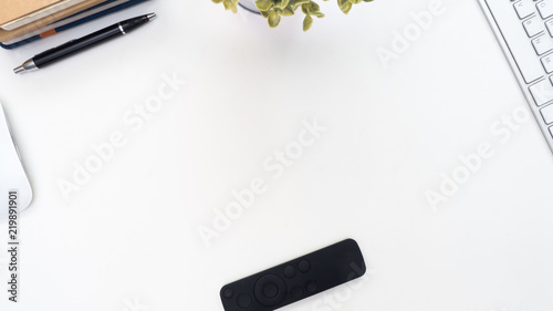 Office desk table with ,keyboard, pen ,plant,notebook and remote. Top view with copy space © boyhey