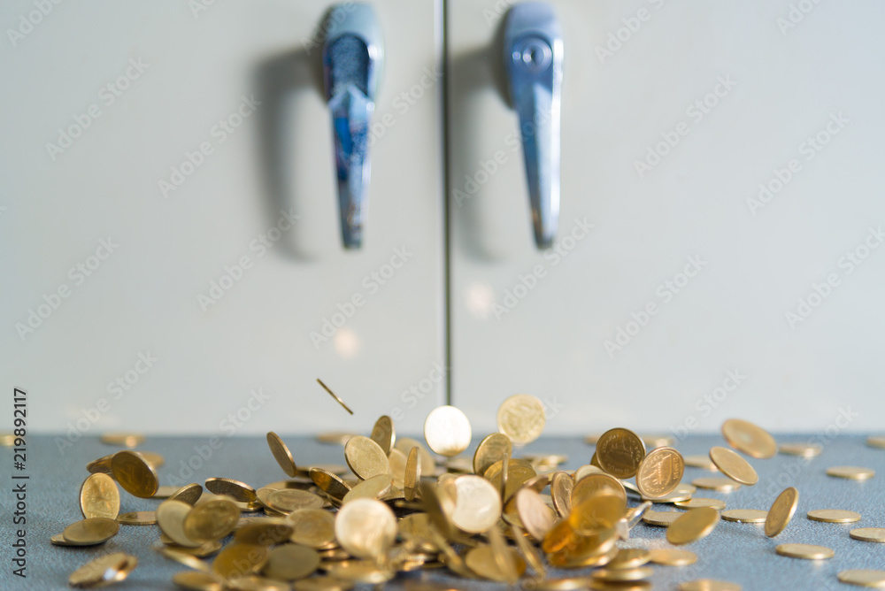 Falling gold coins money on office table with document cabinet background, business money and finance concept.