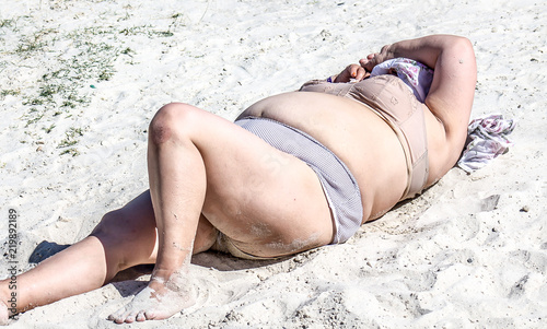 Mature fat woman sunbathing on the beach