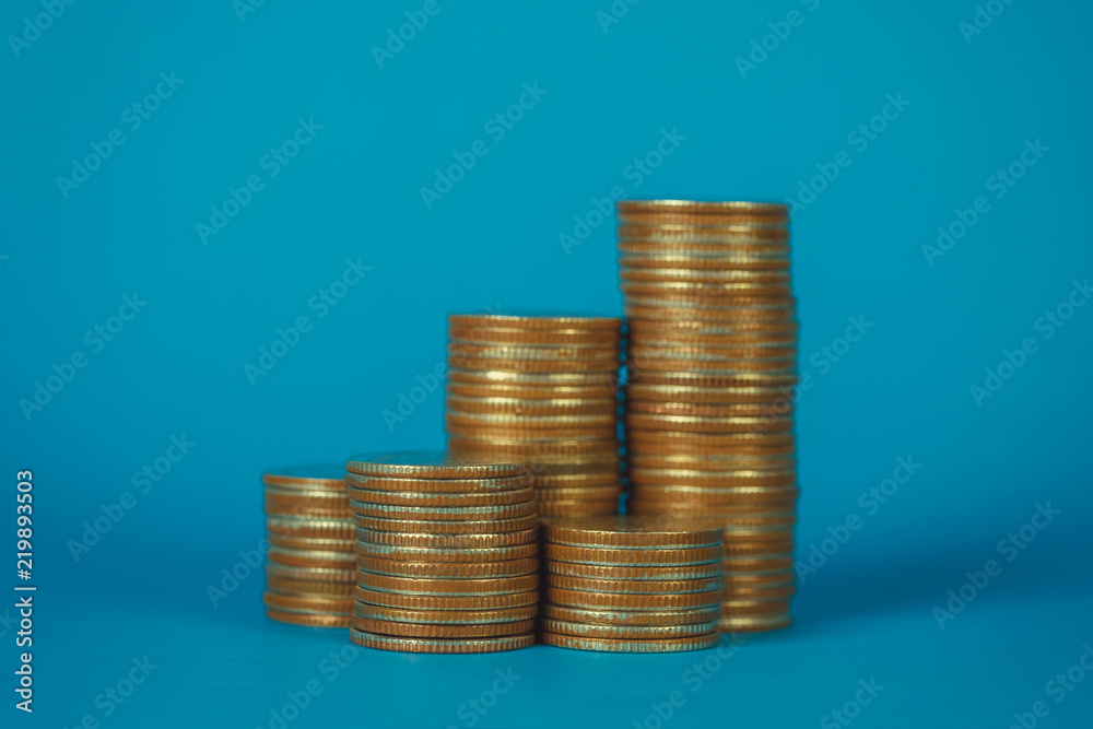Columns of coins, piles of coins on blue background, business and financial concept. Columns of coins, piles of coins on blue background, business and financial concept.