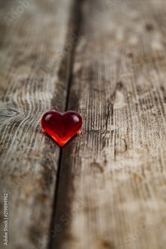 Red glass heart on a wooden background