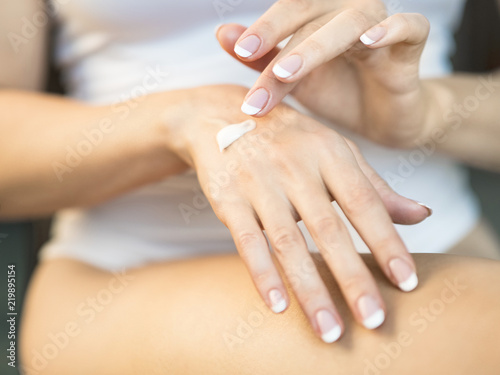 Young woman applying hand cream, closeup view