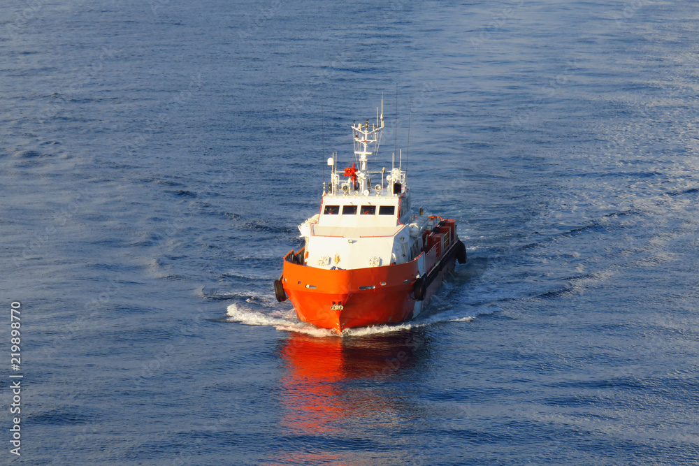 Fototapeta premium Supply boat transfer cargo to oil and gas industry and moving cargo from the boat to the platform. Boat is waiting transfer cargo and crews to platform.
