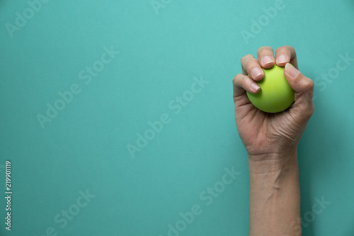 woman holding stress ball on green background