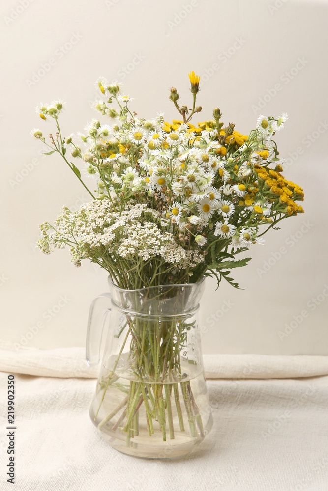 Vase with bouquet of wildflowers. Bouquet of wild flowers in glass pitcher.