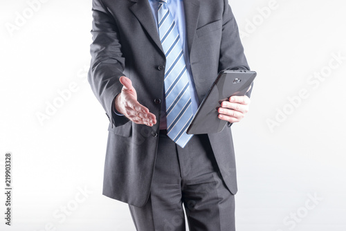 Geschäftsmann mit einem Tablet PC begrüsst den Kunden