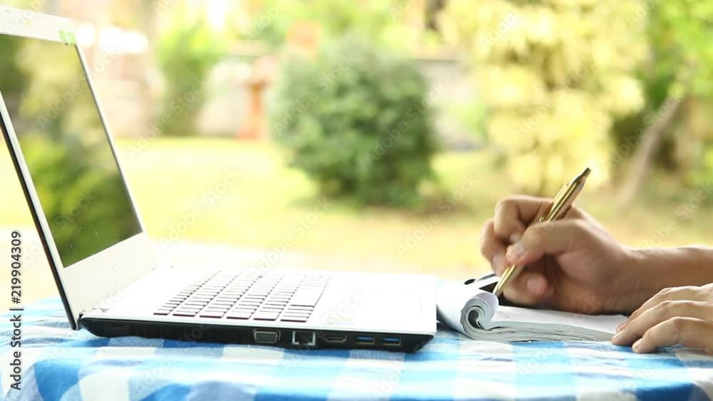Man writing and monitoring stock price in coffee shop, outdoor chiangmai Thailand Man writing and monitoring stock price in coffee shop, outdoor chiangmai Thailand