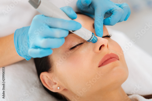 Face cleansing. Face of a nice goo looking woman during hydrafacial procedure in the beauty salon