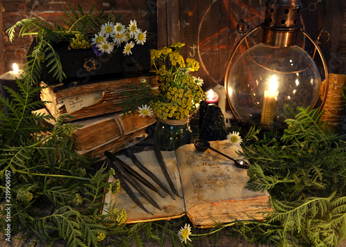 Still life with book with magic spellings, herbs, black candle and old lamp. Mystic background with ritual esoteric objects, occult, fortune telling and halloween concept