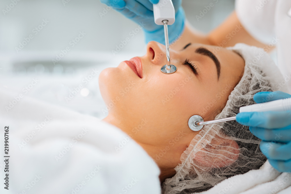 Naklejka premium MCT device. Close up of special device pressed to the skin during the microcurrent therapy