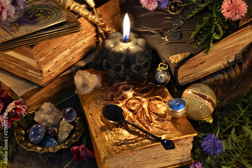 Still life with antique witch book, black candle and ritual objects. Mystic background with ritual esoteric objects, occult, fortune telling and halloween concept