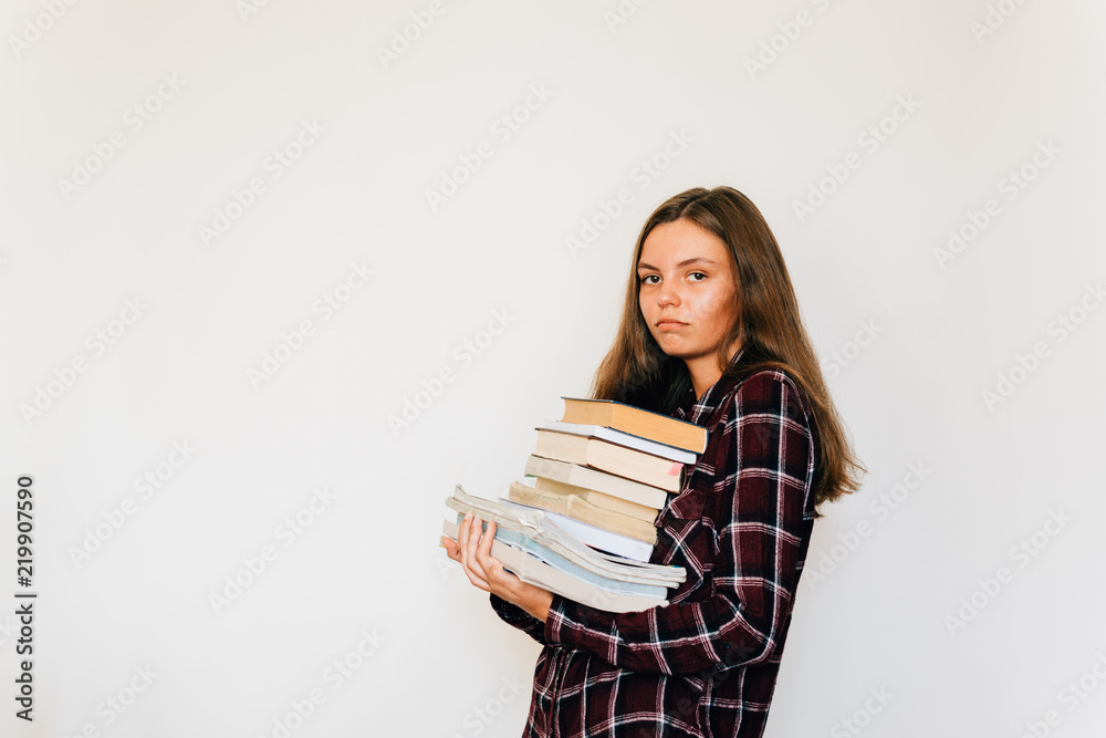 Unhappy teen girl student in college or university with stack of books white background Unhappy teen girl student in college or university with stack of books white background