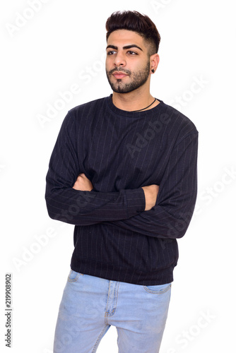 Studio shot of young handsome Indian man with arms crossed isola