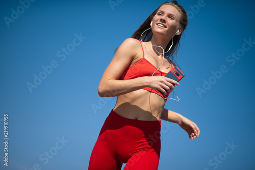 Young fitness woman running on sky backround. The concept of a healthy lifestyle