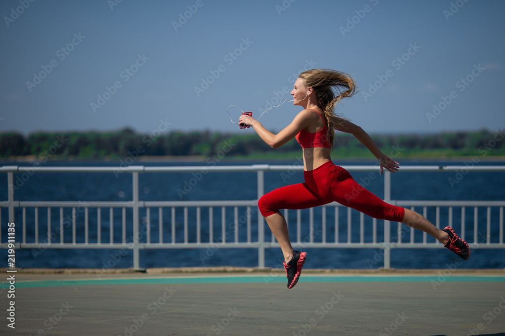 Young fitness woman running on the coast. The concept of a healthy lifestyle Young fitness woman running on the coast. The concept of a healthy lifestyle