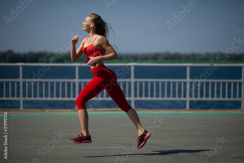 Young fitness woman running on the coast. The concept of a healthy lifestyle