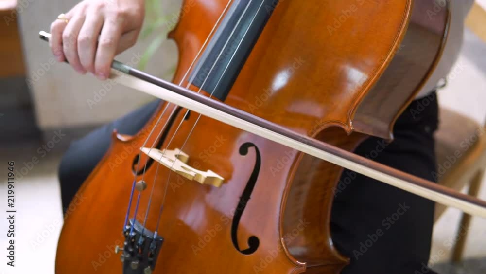 Man Hand Playing Violoncello With Cello Bow. Close up of Male Hand Playing Cello With Cello Bow. Classical Orchestra Musician Man Hand Playing Violoncello With Cello Bow. Close up of Male Hand Playing Cello With Cello Bow. Classical Orchestra Musician