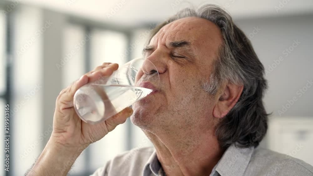 Old man drinking a glass of water Old man drinking a glass of water