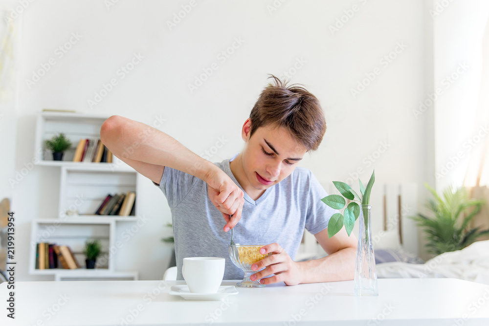 Young man drinking coffee and having breakfast