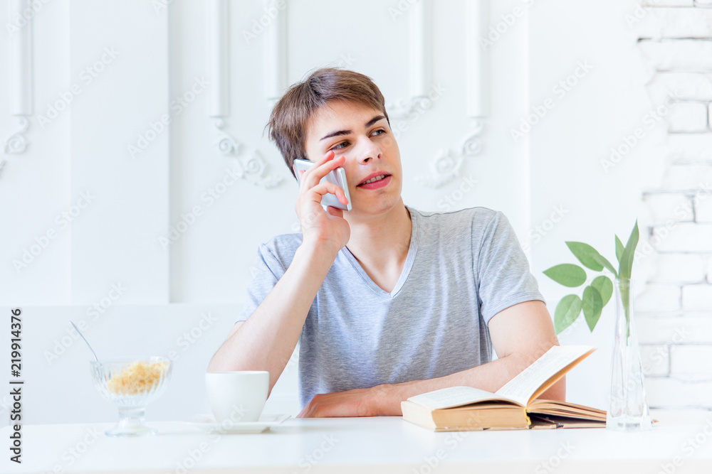 Young man drinking coffee and having breakfast
