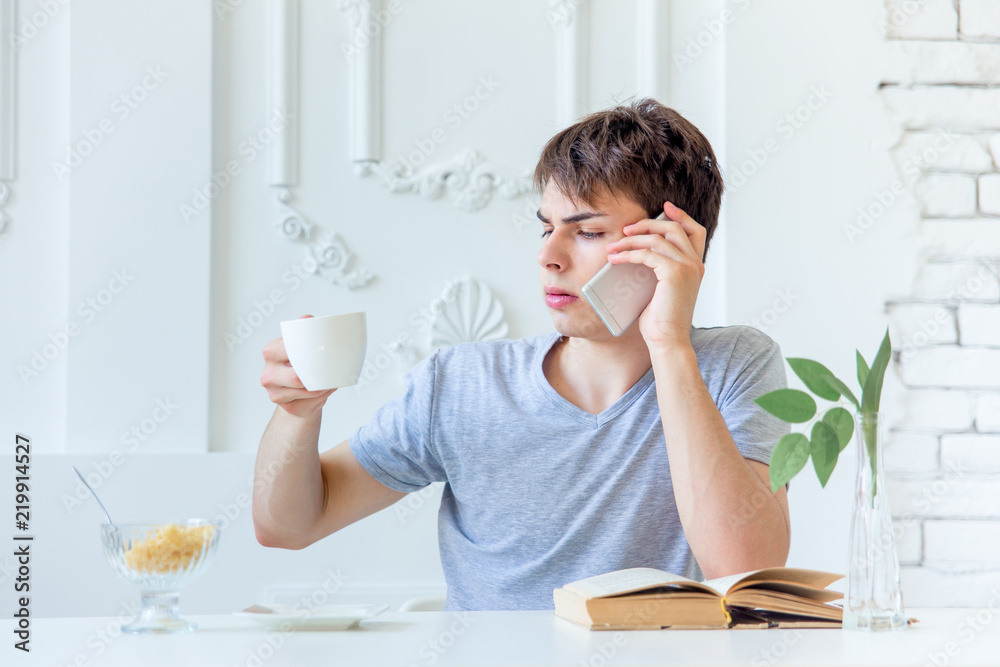 Young man drinking coffee and having breakfast