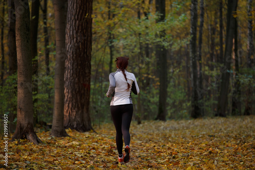 Photo from back in full growth of brunette running in forest © Sergey