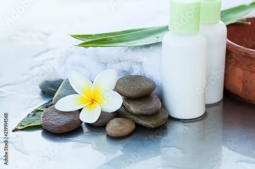 Towel and two cream tubes with flower and stones. Body care and spa concept