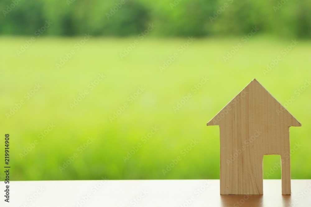 miniature wood house on green background with sunlight.Dream home with nature,mini icon. miniature wood house on green background with sunlight.Dream home with nature,mini icon.