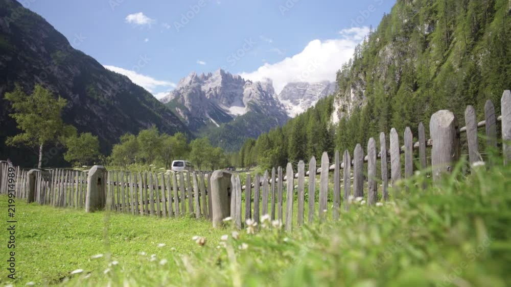 Cesped con valla de madera en un valle de Dolomitas, Alpes Italianos