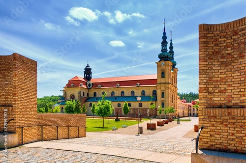 Famous pilgrimage centre Velehrad, Czech Republic with its basilica and beautiful surroundings. Blue sky background contrasts to a orange and red colors of buildings. Typical sunny summer day.