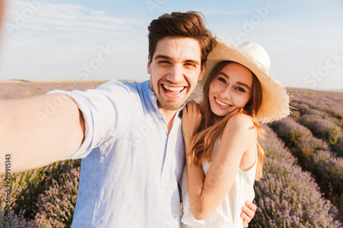 Beautiful young couple taking a selfie while hugging