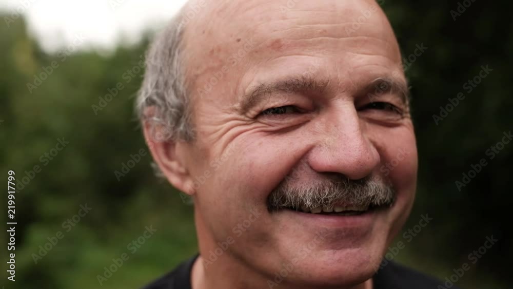 Happy mature man smiling. Outdoor and close up view. Happy mature man smiling. Outdoor and close up view.