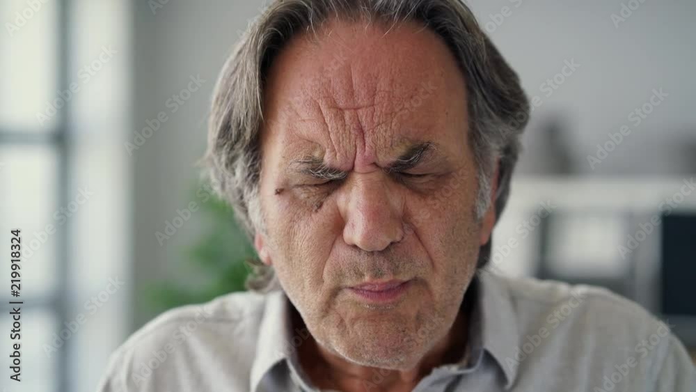 Old man with sensitive teeth holding a glass of cold water Old man with sensitive teeth holding a glass of cold water