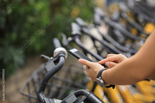 People hands using smartphone scanning the QR code of shared bike in city