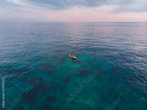 BUDVA, MONTENEGRO - July 21, 2018: two people at surfboard on sea on sunset