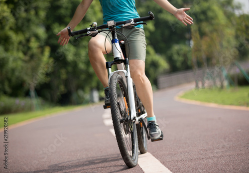 Fototapeta Naklejka Na Ścianę i Meble -  happy woman cyclist riding bike in spring tropical park